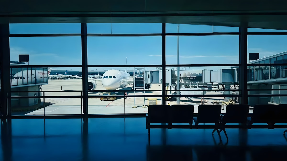 Aircraft at the gate seen through a terminal window